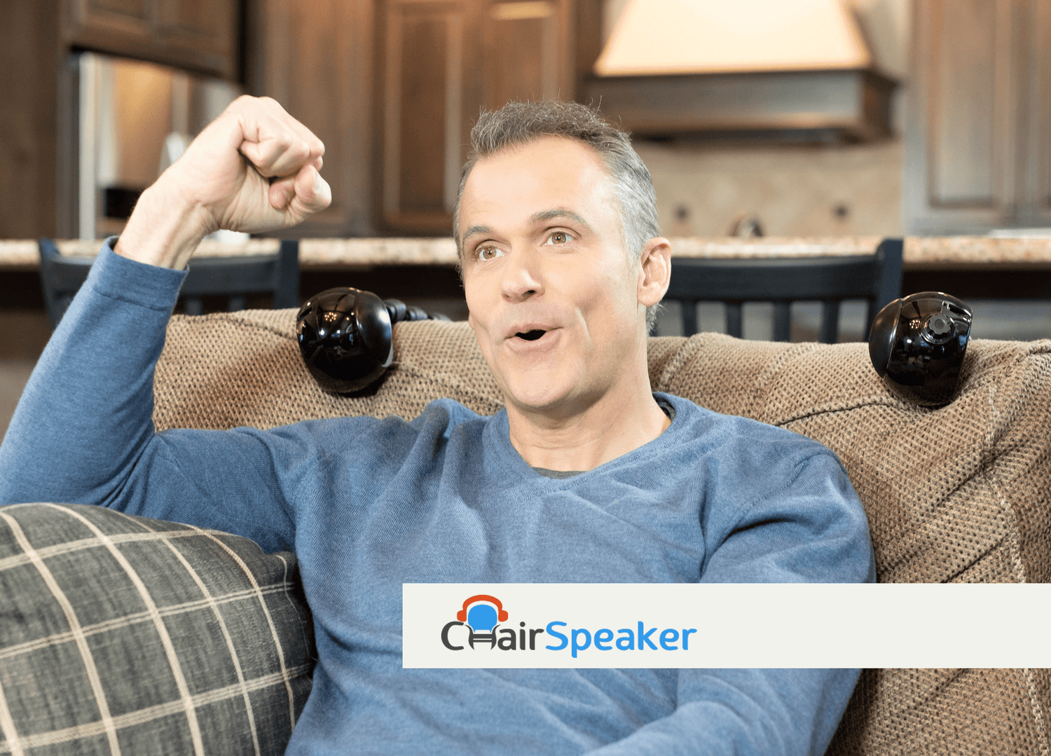 Man lounging on a couch with ChairSpeaker units attached, enjoying his personal sound zone without headphones, demonstrating the ease and comfort of the ChairSpeaker system.